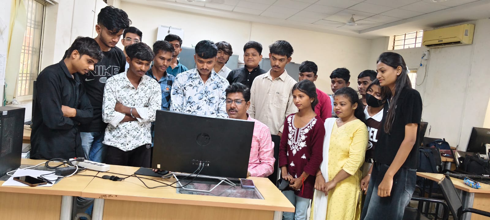 COPA trainees gathered around a computer during a lab session