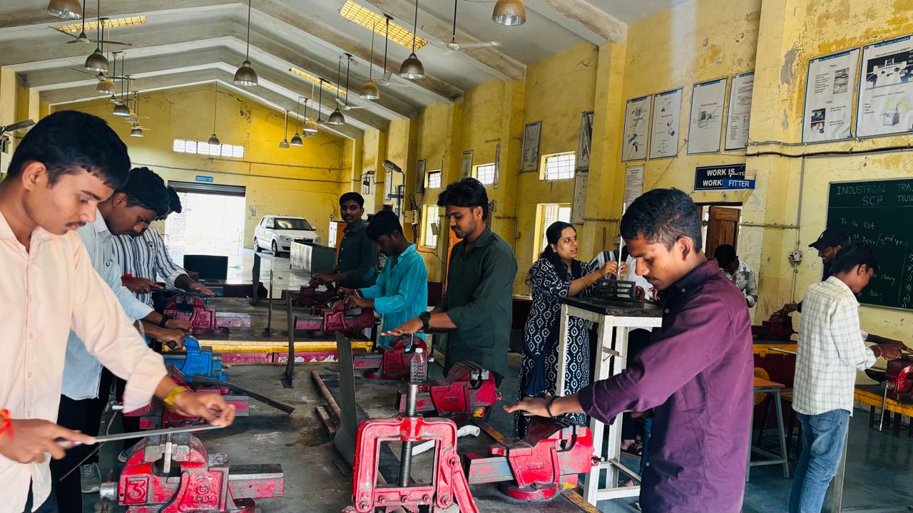 Fitter trainees practising filing on job pieces